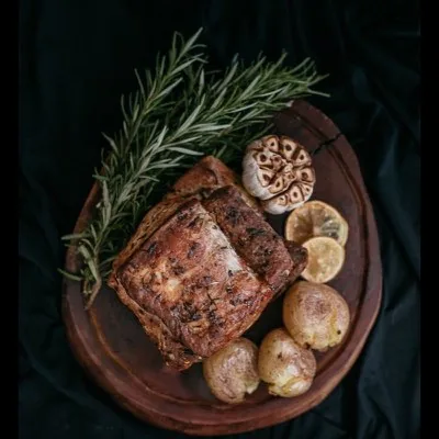 Rôti de porc et aromates sur une planche en bois